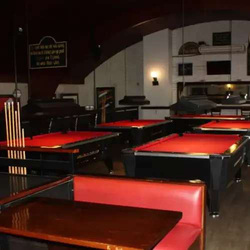 Salón de pool de Snack Bowling con las cinco mesas de paño rojo